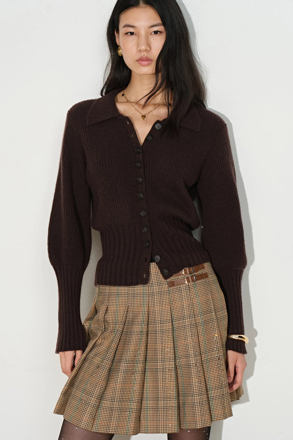 Mocha fitted knit cardigan with sculpted gigot sleeves and button front styled with a plaid pleated skirt