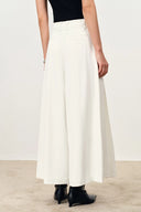 White wide leg culottes with a flowing A line silhouette styled with a black top and ankle boots