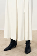 Cream wide leg culottes paired with black pointed ankle boots