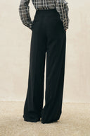 Black pinstripe wide leg pants with a high waist and relaxed tailoring