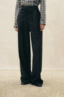 Black pinstripe wide-leg pants with a tied scarf waist and fluid drape