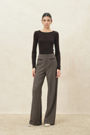 Model wearing high waisted plaid wide leg wool blend pants with a structured front seam