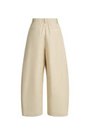 Cream cotton blend barrel leg pants with an elastic drawstring waist and curved wide legs