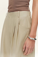 Womens beige cotton blend barrel leg pants with a relaxed curved wide leg silhouette