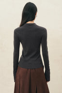 Back view of a charcoal fitted stretch knit polo top with metal sleeve accents