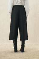 Black cropped wide leg wool blend pants styled with a white blouse and black boots