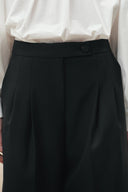 Black cropped wide leg wool blend pants with pleated front and button waistband