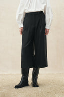 Black cropped wide leg wool blend pants styled with a white blouse and black boots