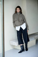 Model wearing navy cropped wide leg wool blend pants with a structured silhouette