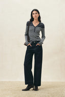 Gray striped Henley knit top with long sleeves styled with wide leg pants and ankle boots